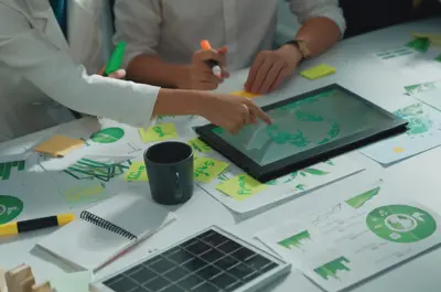 Two people with documents and a computer making green energy plans